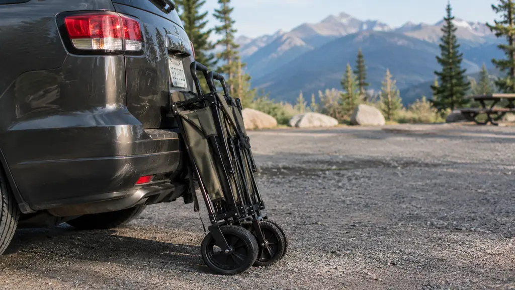 A folded wagon leaning against the rear bumper of an SUV